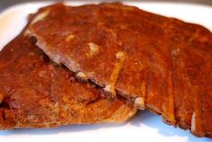 two pieces of meat sitting on top of a white plate