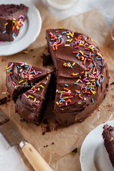 there is a chocolate cake with sprinkles on the top and one slice missing