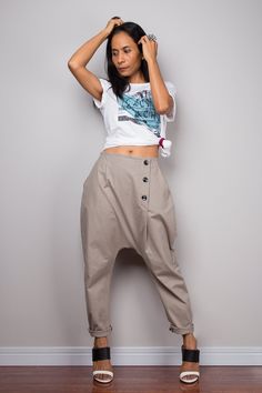 These  harem pants feature a smart linear and a fashionable low crotch design for a more comfy effect. Two pockets, a zipper on the front and extra buttons make these urban pants more attractive and the elastic on the back helps the fit  Made with the highest care this beautifully street styled garment will fit you perfectly. The idea is a support to mix and match with any kind of tops or shirt, depends on your own style and occasion.  These light brown natural linen pants come in One Size (free size)  Please make sure these pants will fit you before placing your order.  Waist: fits from 24 - 36" (inch) Hips: up to 44" (inch) Waist to crotch: 16" (inch) Length: 36" (inch) from waist til hem  NOTE :  * Model chest : 32", waist : 24" hips : 35"  * Combined Height is 5"6 > I'm 5"2 (158cm) and Natural Linen Pants, Linen Harem Pants, Unisex Pants, Drop Crotch Pants, Harem Pants Women, Baggy Trousers, Pants With Pockets, Brown Pants, Baggy Pants