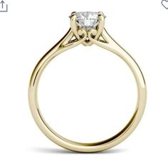 a yellow gold engagement ring with a princess cut diamond in the center, on a white background