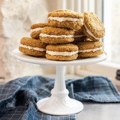 a stack of cookies sitting on top of a white cake plate