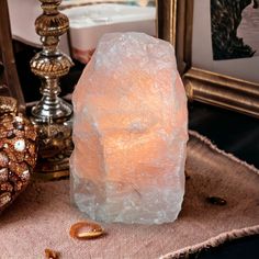 a large white rock sitting on top of a table next to a gold candle holder