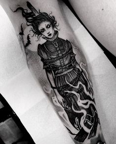 a black and white photo of a woman's leg with tattoos on her legs