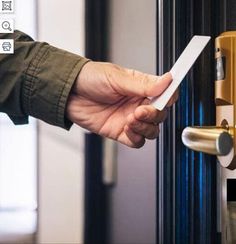 a hand is holding a piece of paper in front of a door with a lock on it