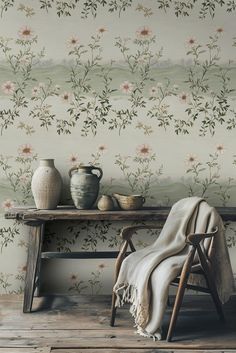 a wooden table with a vase on top of it next to a chair and wall paper