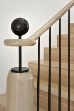 a black ball sitting on top of a wooden banister