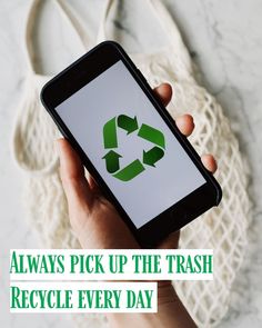 a person holding a cell phone with a recycle logo on the screen in front of a white bag