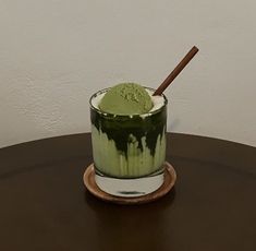 a green drink sitting on top of a wooden table