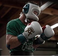 a man in green shirt and white boxing gloves