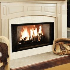 a fire place in a living room with logs on the floor and a chair next to it