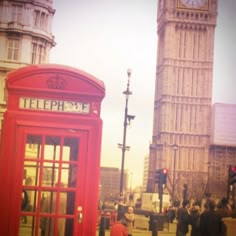 the big ben clock tower towering over the city of london, and red telephone booth