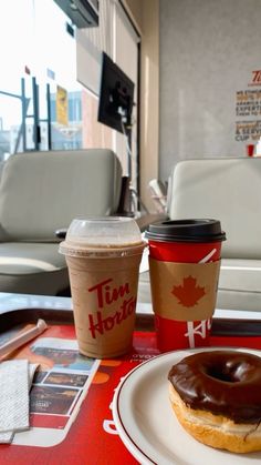 a donut and cup of coffee sit on a table in a diner's restaurant