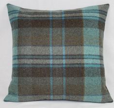 a brown and blue plaid pillow on a white background