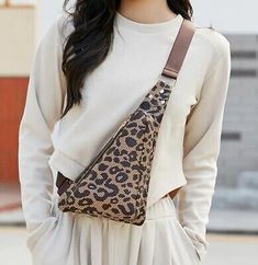 a woman wearing a white top and brown leopard print purse