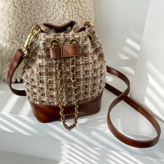 The EMES SHOP bag details a woven tweed-like material into a small basket shape. Features an adjustable string in the front and a removable strap. this satchel is the perfect fit for your summer outfits.MATERIAL:100% Vegan Leather & PolyesterMEASUREMENTS:H" X W"X D" 17.5cm X 18.5cm X 9cm 6.9in X 7.3in X 3.5in Chic Woven Shoulder Bag For Fall, Chic Tweed Bags With Detachable Strap, Beige Casual Bucket Bag For Fall, Casual Brown Bucket Bag For Fall, Casual Beige Bucket Bag For Fall, Fall Tweed Shoulder Bag, Everyday Tweed Crossbody Bag, Chic Tweed Crossbody Shoulder Bag, Casual Woven Shoulder Bag For Errands