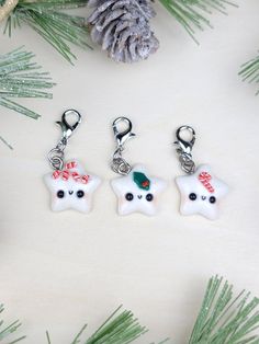 three christmas themed charms hanging from a pine tree