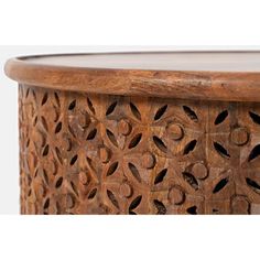 an intricately carved wooden table with glass top on white background, close up view