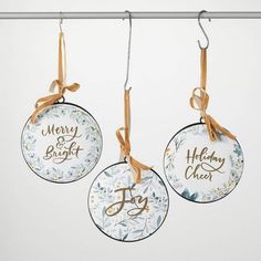 three christmas ornaments hanging from a clothes line with the words merry and bright on them