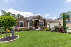 a house with landscaping in front of it and trees on the other side of the house