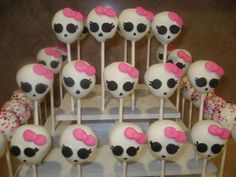 the cake pops are decorated with skulls and pink bows