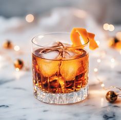 an old fashioned cocktail with orange peel and ice