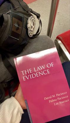 the law of evidence by david m pacuccio is held up in someone's lap