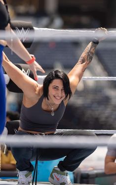 a woman is sitting on the ground with her arms in the air