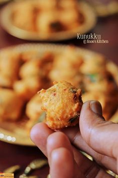 a hand is holding up some food on a plate