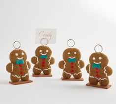 four gingerbread keychains with tags attached to them, one is wearing a bow tie and the other has a name tag