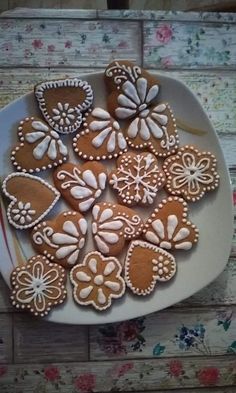 some cookies are on a white plate with pink flowers and hearts in the middle one cookie has been cut out to look like butterflies