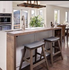 a kitchen island with stools in front of it