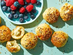 blueberries, raspberries and poppy seed muffins are arranged on a table