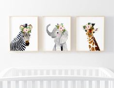 three pictures of animals are hanging on the wall above a crib in a baby's room