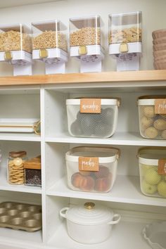 the shelves are filled with different types of food and storage bins, labeled with labels on them