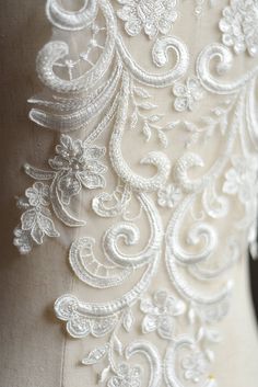 the back of a wedding dress with an intricate lace design and beading on it