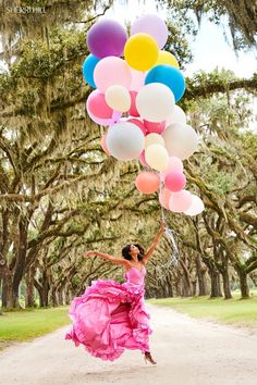 a woman in a pink dress is holding balloons