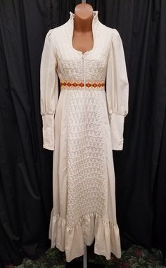 Vintage 1970's Gunne Sax Cream/Ivory Thick Quilted Cotton w Floral Trim and Sweetheart Neckline Maxi Dress, Rare, Collector.   Dress is in amazing vintage condition - except for couple of orangish imperfections on the right sleeve and the left back shoulder...see pics!  Dress has a gorgeous sweetheart neckline with a lace up detail, sleeve cuffs with zippers, a back zipper closure, and floral embroidered waistband. Measurements: waist 25, bust 34, sleeve shoulder to cuff 26, sleeve pit to cuff 2 Fitted Cream Prairie Dress, Traditional Fitted Cream Dress, Fitted Vintage Cream Prairie Dress, Vintage Fitted White Prairie Dress, Fitted Vintage White Prairie Dress, Fitted White Vintage Prairie Dress, White Fitted Retro Prairie Dress, 1970s Fitted Beige Dress, Retro Fitted White Prairie Dress