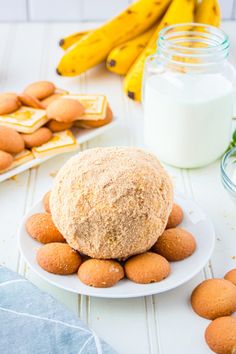 a plate with some cookies on it next to bananas and yogurt in a glass jar