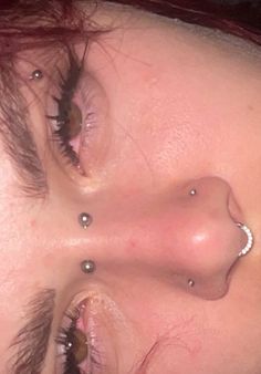 a woman with piercings on her nose looking at the camera