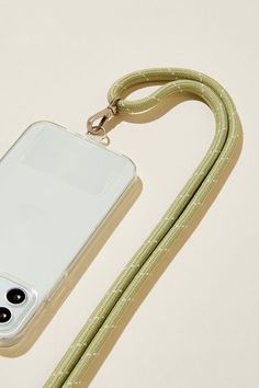 an iphone case with a lanyard attached to it on a white surface next to a green cord