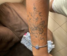 a woman's arm with a butterfly tattoo on it and a blue beaded bracelet