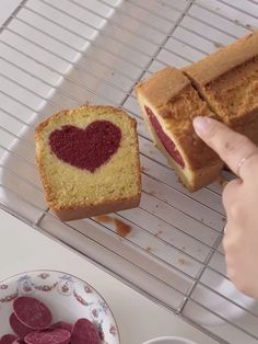 a heart shaped cake sitting on top of a cooling rack next to a bowl of jelly hearts