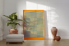 an orange and blue art piece next to a chair in a white room with potted plants