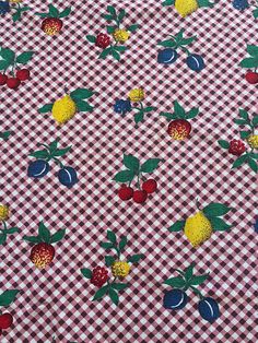 a checkered table cloth with cherries and lemons on it