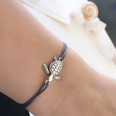 "ANKLET - Perfect summer beach accessory. Bracelets Are Unisex - Anyone Can Wear It. Nylon thread cord does not fade or stain skin, perfect for everyday wear! ▫️SIZE Easily adjustable by moving the knots closer or away. 🐢 ANKLET each opens from 9\"to 12 inches. ( ONE SIZE ) 🐢 BRACELET each opens from 6\" to 7.5 inches. ( ONE SIZE ) ▫️MATERIALS: 24K Gold Plated Charm Turtle/ Silver Plated Metal - Brass ( Lead and Nickel Free) Turtle Charm size 2cm 100% Nylon Cord (Grey in pictures) Multiple Use Silver Friendship Bracelets For Summer Beach, Silver Friendship Bracelets For Beach In Summer, Summer Beach Silver Friendship Bracelets, Adjustable Braided Nylon Cord Bracelet For Beach, Adjustable Nylon Cord Braided Bracelet For Beach, Resizable Silver Friendship Bracelets For Beach, Adjustable Silver Braided Bracelet For Beach, Adjustable Strand Braided Bracelets As Gift, Adjustable Strand Braided Bracelets For Gift