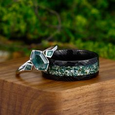 two bracelets sitting on top of a wooden table next to green plants and trees