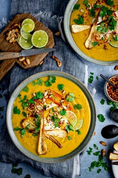 two bowls filled with soup and garnished with limes