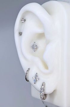 a pair of ear piercings sitting on top of a white object