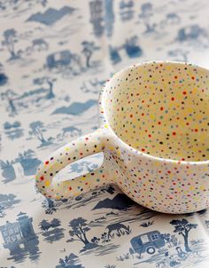 a polka dot cup sitting on top of a table