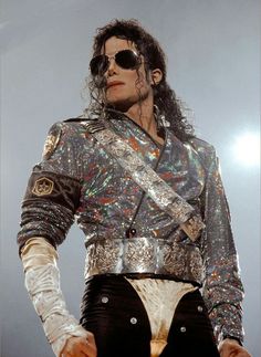 michael jackson as michael jackson from the movie michael jackson is wearing sunglasses and has his hand on his hip